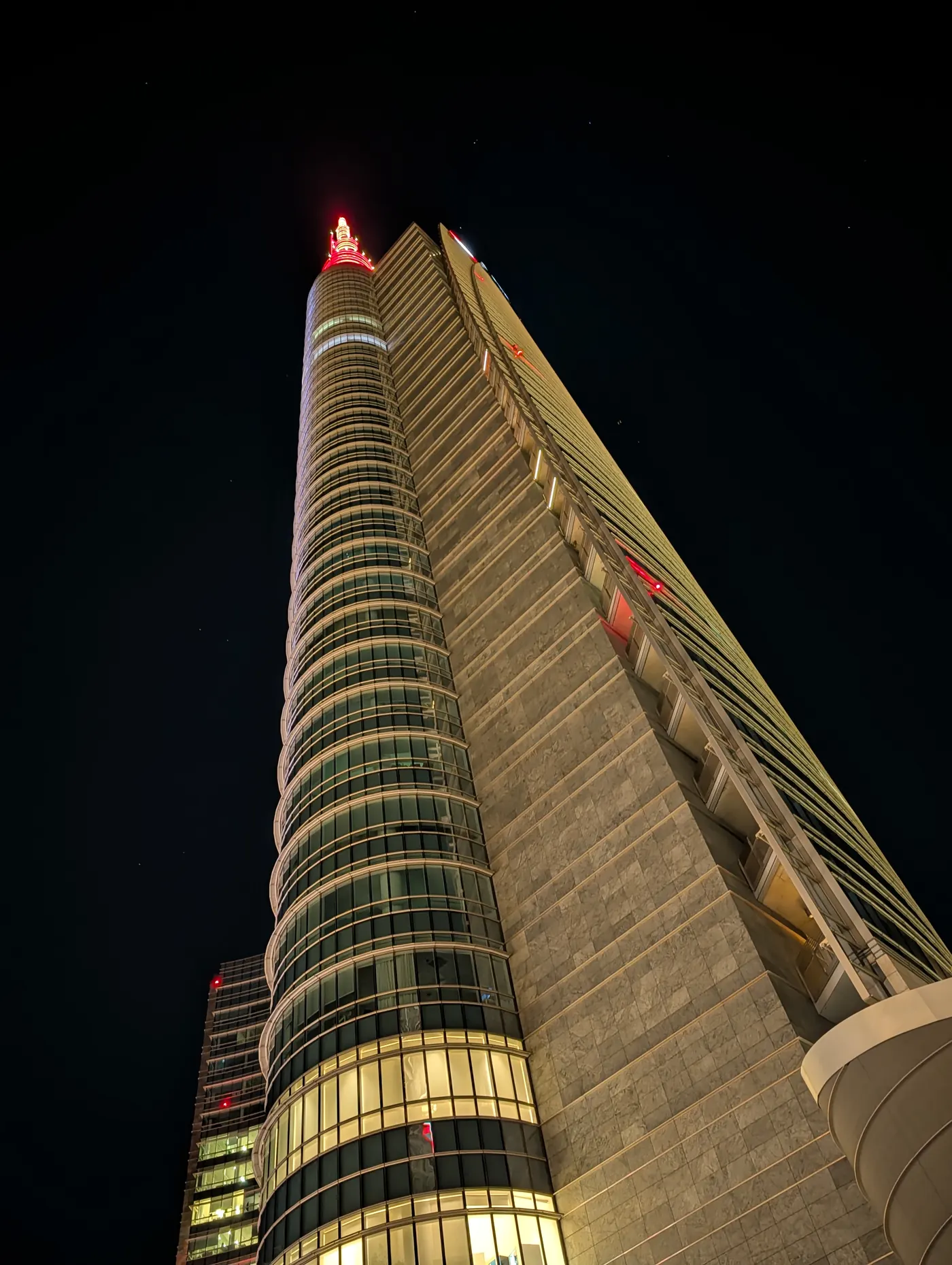 A Porta Nuova tower and its lit spire against the night sky, Milano